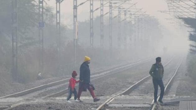 People wearing winter clothes cross tracks at Mohamadpur Railway Station amid morning chill and cold weather near Dwarka. (Vipin Kumar/HT PHOTO) People wearing winter clothes cross tracks at Mohamadpur Railway Station amid morning chill and cold weather near Dwarka. (Vipin Kumar/HT PHOTO)