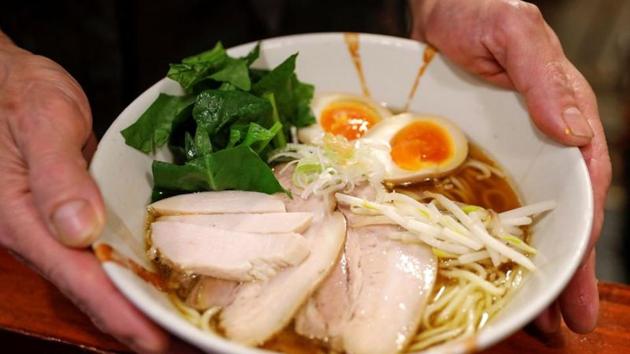 Haga serves ramen at his noodle shop in Tokyo on November 20. According to Takeshi Yamamoto, an independent ramen critic who tracks shop closures, the wave of noodle shop closing started with those who were already on edge with their business such as elderly owners, then followed some noodle chains and those businesses that could not pay their landlord’s mounting rent. (Issei Kato / Reuters)