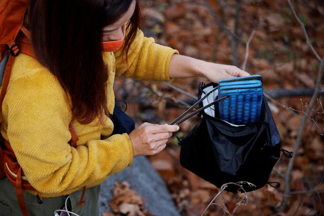 Kim Kang-Eun collects a litter while hiking a mountain in Incheon, South Korea, November 16, 2020. (REUTERS)