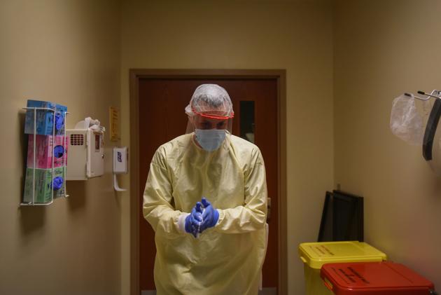 Dr. Drew Miller uses hand sanitizer as healthcare personnel treat patients with the coronavirus disease.(REUTERS)