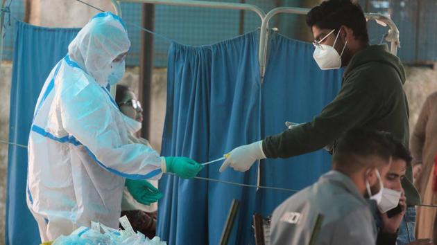 A medic in PPE places a collected swab sample into a container for a coronavirus test at a hospital in Jaipur.(Himanshu Vyas/HT PHOTO) A medic in PPE places a collected swab sample into a container for a coronavirus test at a hospital in Jaipur.(Himanshu Vyas/HT PHOTO)