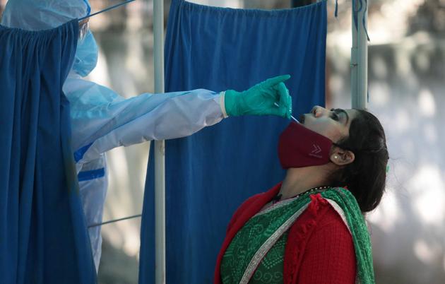 A medic in PPE collects a swab sample from a woman for coronavirus testing, at Kanwatiya Hospital, in Jaipur, Rajasthan.(Photo by Himanshu Vyas/ Hindustan Times)
