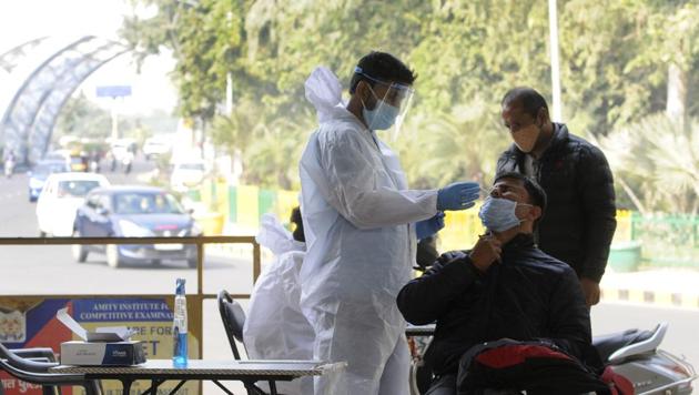 Noida, India - November 23, 2020: A medical worker in PPE collects a sample from a commuter arriving from Delhi to test for coronavirus infection, at Sector 14A Uttar Pradesh-Delhi border, in Noida, India, on Monday, November 23, 2020. (Photo by Sunil Ghosh / Hindustan Times) Noida, India - November 23, 2020: A medical worker in PPE collects a sample from a commuter arriving from Delhi to test for coronavirus infection, at Sector 14A Uttar Pradesh-Delhi border, in Noida, India, on Monday, November 23, 2020. (Photo by Sunil Ghosh / Hindustan Times)