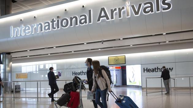 Passengers wearing face masks arrive at London's Heathrow Airport.(AP file)