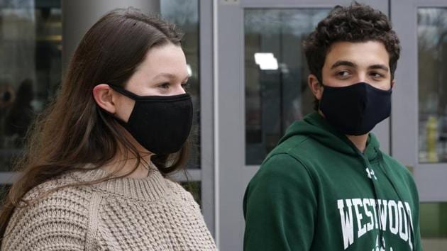 While wearing protective masks due to the COVID-19 outbreak, Lucy Vitali, who portrays Juliet, left, stands with Alex Mansour, who portrays Romeo, outside the auditorium after working on their virtual performance of Shakespeare's "Romeo and Juliet," at Westwood, Mass. High School, Monday, Nov. 16, 2020, in Westwood. The production, which would usually be presented onstage, shifted to a virtual audience due to the pandemic.(AP)