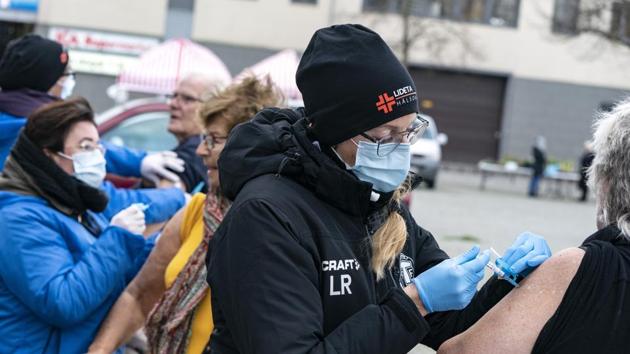 Nursing staff administer flu vaccines to high risk group patients, outdoors to prevent the spread of the coronavirus, in Trelleborg, southern Sweden.(AP)