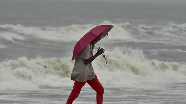 A man walks along a shore before the landfall of Cyclone Nivar, at Marina Beach in Chennai on Tuesday.(PTI Photo)