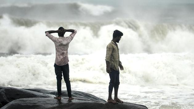 People stand on a rock while waves lash at Kovalam beach as Cyclone Nivar approaches the eastern Indian coast, in Chennai. (AFP) People stand on a rock while waves lash at Kovalam beach as Cyclone Nivar approaches the eastern Indian coast, in Chennai. (AFP)