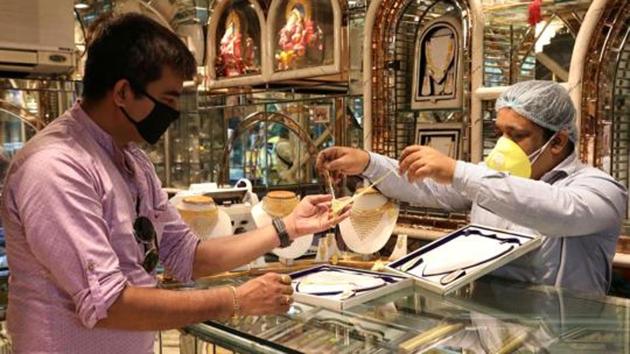 A salesman shows gold necklaces to a customer at a jewellery showroom in Kolkata in this file photo.(Reuters Photo)