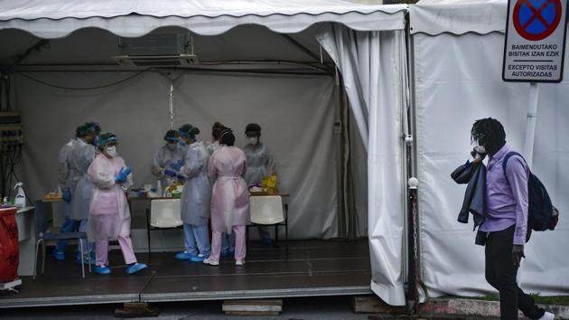 Mbaye Babacar Diouf, right, walks by a special coronavirus checkpoint, at Basurto hospital, in Bilbao, northern Spain, Wednesday, Nov. 18, 2020. Mbaye Babacar Diouf's life as a migrant in Europe took a turn for the better when he was adopted in Spain at the age of 28. That enabled him to pay his debts to human traffickers, study nursing and find a job at a Spanish hospital. Now he's giving back to the community. In a Bilbao hospital he cares for COVID-19 patients.(AP)