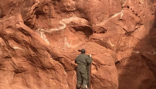 This photo provided by the Utah Department of Public Safety shows Utah state workers checking out a metal monolith that was found installed in the ground in a remote area of red rock in Utah. The smooth, tall structure was found during a helicopter survey of bighorn sheep in southeastern Utah, officials said Monday.(AP) This photo provided by the Utah Department of Public Safety shows Utah state workers checking out a metal monolith that was found installed in the ground in a remote area of red rock in Utah. The smooth, tall structure was found during a helicopter survey of bighorn sheep in southeastern Utah, officials said Monday.(AP)