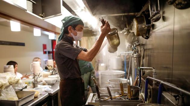 Sixty-year-old Yashiro Haga cooks ramen noodles at his noodle shop 'Shirohachi' amid the coronavirus disease (COVID-19) outbreak, in Tokyo on November 20. (Issei Kato / REUTERS)