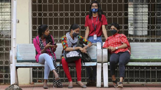 Students wearing face masks as a precaution against the coronavirus spend time between their classes.(AP file photo)