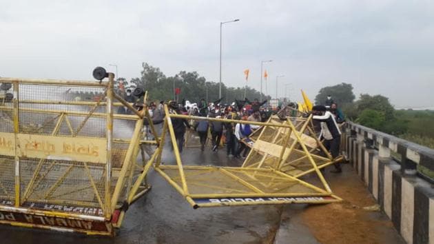 Punjab farmers breaking through the barricades put up by Haryana Police at Shambu barrier on the border of Ambala and Patiala districts on Thursday. Tear gas and water cannons could not stop the farmers from marching to Delhi to protest against the Centre’s farm laws.(Bharat Bhushan/HT)