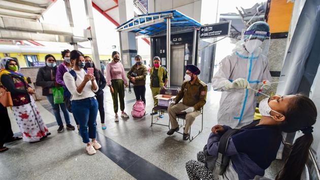 A health worker, wearing protective gear, collects swab sample of a passenger at Nizamuddin Railway Station in New Delhi.(PTI) A health worker, wearing protective gear, collects swab sample of a passenger at Nizamuddin Railway Station in New Delhi.(PTI)