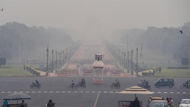 Vehicles ply at Vijay Chowk amid low visibility due to smog, in New Delhi.(PTI)