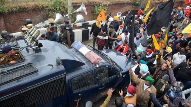 Farmers block a police vehicle during their march to New Delhi, in Ambala on November 26. Police officials at the Shambhu inter-state border had at first used loud speakers, asking farmers who had assembled on the Punjab side to disperse when some of them tried to cross and remove the barricades, PTI reported. (AFP) Farmers block a police vehicle during their march to New Delhi, in Ambala on November 26. Police officials at the Shambhu inter-state border had at first used loud speakers, asking farmers who had assembled on the Punjab side to disperse when some of them tried to cross and remove the barricades, PTI reported. (AFP)