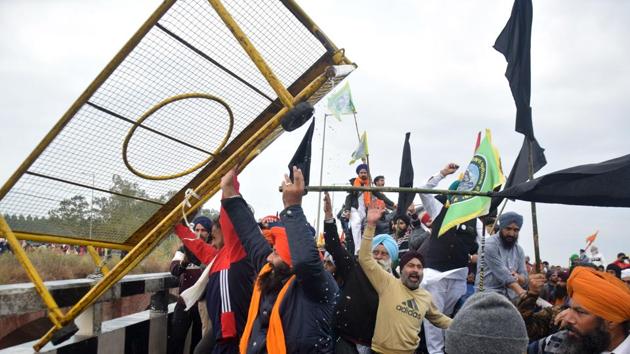 Farmers remove a police barrier blocking a road during their protest march to New Delhi on the outskirts of Ambala on November 26. The situation remained tense at the Shambu inter-state border as protesting farmers threw police barricades into the Ghaggar river.Some protestors were also seen waving black flags. (AFP) Farmers remove a police barrier blocking a road during their protest march to New Delhi on the outskirts of Ambala on November 26. The situation remained tense at the Shambu inter-state border as protesting farmers threw police barricades into the Ghaggar river.Some protestors were also seen waving black flags. (AFP)