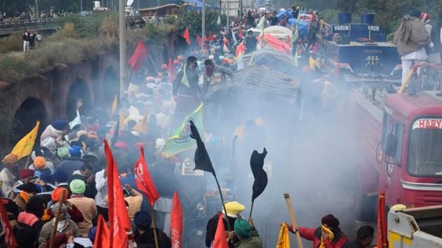 Tear gas is fired by the police to disperse and impede farmers in Ambala on November 26. Farmers have given a call for the march to coincide with the Constitution Day. While the government says the three reform laws will do away with middlemen, enabling farmers to sell their produce in the commercial markets, protestors fear that this could lead to disruptions of existing structures and exploitation by corporate buyers. (AFP) Tear gas is fired by the police to disperse and impede farmers in Ambala on November 26. Farmers have given a call for the march to coincide with the Constitution Day. While the government says the three reform laws will do away with middlemen, enabling farmers to sell their produce in the commercial markets, protestors fear that this could lead to disruptions of existing structures and exploitation by corporate buyers. (AFP)