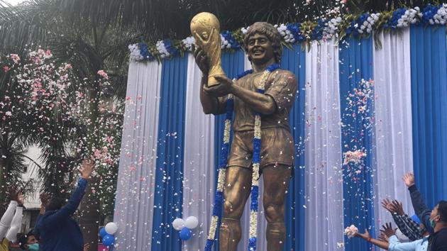 Fans pay homage by showering petals on a statue of Maradona at Lake Town in Kolkata, India on November 26. (Samir Jana / HT Photo)