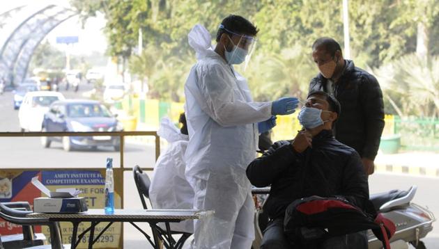 A medical worker collects a sample from a commuter arriving from Delhi to test for coronavirus infection at the Noida border.(Sunil Ghosh?HT PHOTO) A medical worker collects a sample from a commuter arriving from Delhi to test for coronavirus infection at the Noida border.(Sunil Ghosh?HT PHOTO)