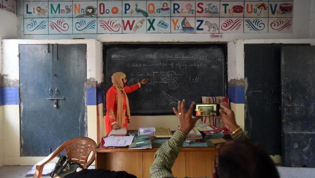 A teacher records a video as his colleague conducts an online class in New Delhi.(Raj K Raj/HT File)