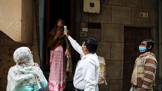A health worker wearing a protective face mask checks the temperature of a woman while conducting door to door survey to identify symptomatic people amid a spike in the Covid-19 cases in New Delhi.(Reuters Photo) A health worker wearing a protective face mask checks the temperature of a woman while conducting door to door survey to identify symptomatic people amid a spike in the Covid-19 cases in New Delhi.(Reuters Photo)