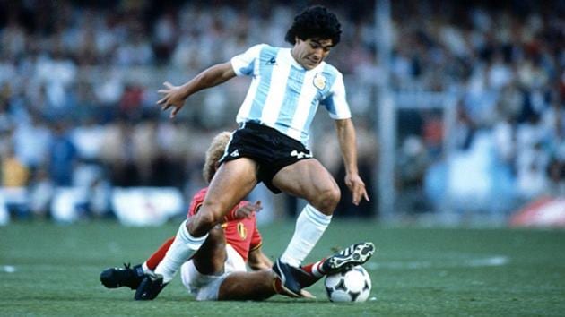 Diego Maradona tackles the ball past a defender.(Getty Images)