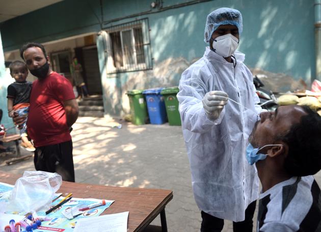 A health worker collects a swab sample of a resident. (Satish Bate/HT Photo) A health worker collects a swab sample of a resident. (Satish Bate/HT Photo)