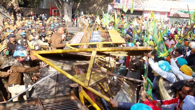 Various farmer union members remove Haryana Police barricades during a protest against the Central government’s farm laws on the Punjab-Haryana border on Friday.(Sanjeev Kumar/HT Photo)