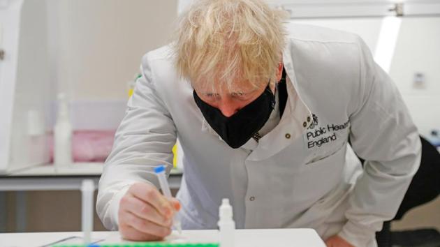 Britain's Prime Minister Boris Johnson looks at samples at the Lateral Flow Testing Laboratory during a visit to the Public Health England site at the Porton Down science park, near Salisbury, Britain on November 27.(REUTERS)