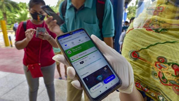 A commuter shows her COVID-19 status via Aarogya Setu app before entering Vaishali station. (File photo)(PTI)