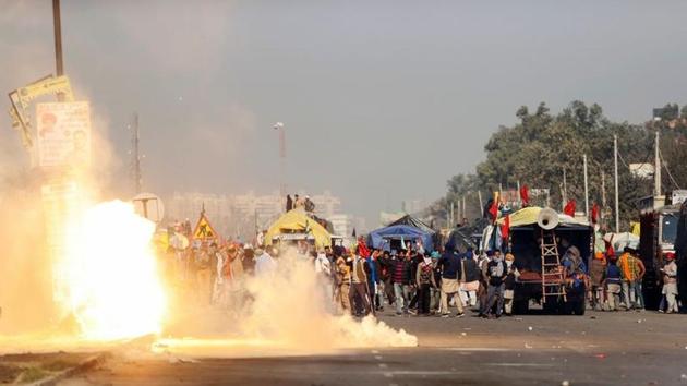 Flames emerge from tear gas released by the police to stop farmers opposing the newly passed farm bills from entering the national capital Delhi, at Singhu border, November 27.(REUTERS)