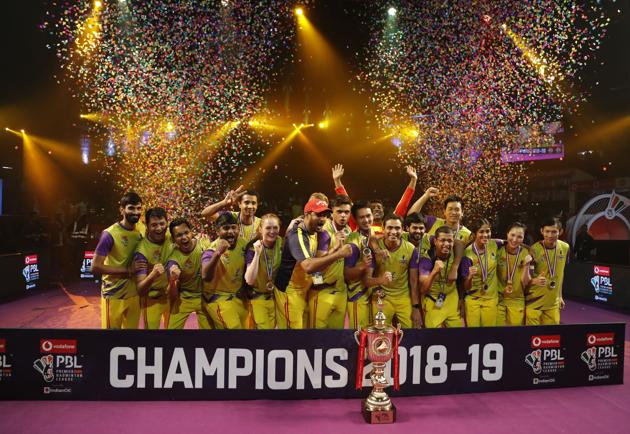 Members of Bengaluru Raptors celebrate with the winners trophy after their win in the finals of Vodafone Premier Badminton League (PBL) in Bangalore, India.(AP)