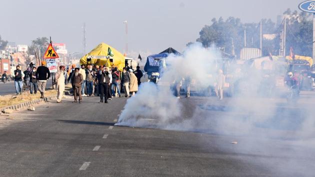 Tear gas shells fired by Delhi Police land near protesting farmers  as they try to cross the border into Delhi, at Singhu border in New Delhi on November 27. (PTI)