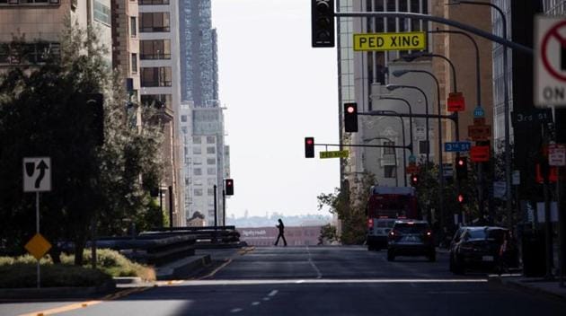A person crosses an empty Grand Ave in downtown during the outbreak of the coronavirus disease in Los Angeles, California.(REUTERS) A person crosses an empty Grand Ave in downtown during the outbreak of the coronavirus disease in Los Angeles, California.(REUTERS)