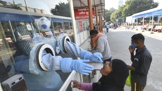 A health worker takes samples for Covid-19 testing at Ram Manohar Lohia Hospital, in Lucknow.(PTI)