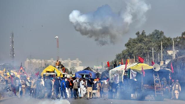 A cloud of tear gas forms from a cannister fired by Delhi Police to disperse farmers waiting to enter the national capital in protest against farm reform laws, at Singhu Border near New Delhi on November 27. After making their way through Haryana, thousands of farmers knocked on the national capital on November 27 under the “Delhi Chalo” call against the agri-marketing laws enacted at the Centre in September. (Sanchit Khanna / HT Photo) 