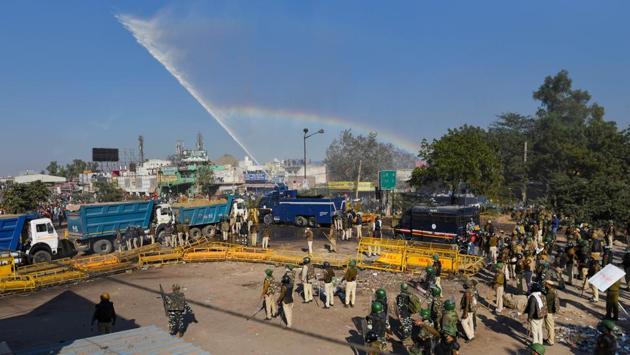 A rainbow forms as a water cannon is fired to disperse farmers at Singhu Border on November 27. While housing arrangements were being ironed out, protesters assembled at Delhi’s border at Tigri and Singhu faced tear gas and water cannons to stop them from breaking through barricades, which included sand-laden trucks. (Sanchit Khanna / HT Photo) 