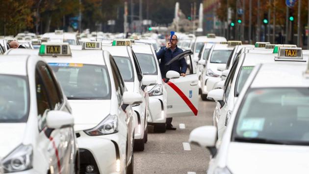 A taxi driver blows a plastic horn during the “go-slow” protest against the lack of support from local authorities towards taxi service providers amid the coronavirus pandemic in Madrid, Spain on November 25.  (Sergio Perez / REUTERS) 