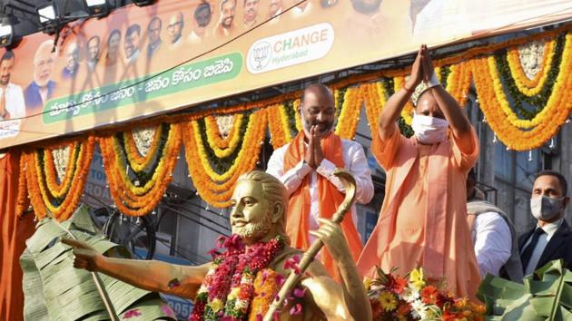 Uttar Pradesh Chief Minister Yogi Adityanath with BJP State president Bandi Sanjay waves at supporters during a roadshow, ahead of GHMC elections in Hyderabad.(PTI)