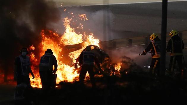 tewards attempt to extinguish flames at the crash scene after Haas' Romain Grosjean crashed out at the start of the race.(Pool via REUTERS) tewards attempt to extinguish flames at the crash scene after Haas' Romain Grosjean crashed out at the start of the race.(Pool via REUTERS)