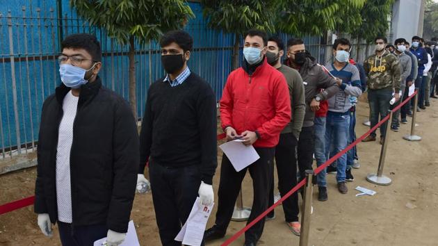 Even as candidates were wearing masks, they were not maintaining adequate distance while lining up outside the exam centre at Satnam Infosol, Threeke Road, on Sunday.(Harsimar Pal Singh/HT)