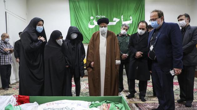 Iran's Judiciary Chief Ayatollah Ebrahim Raisi pays his respect to the body of slain scientist Mohsen Fakhrizadeh among his family, in Tehran, Iran.(AP)