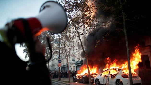 A police officer speaks on a loudspeaker as a car is set on fire by demonstrators in Paris on November 28. An investigation has been opened against the four police personnel involved in the beating of the Black music producer but commentators say that the images -- first published by the Loopsider news site -- may never have been made public if the contentious Article 24 of the security legislation was made law, AFP reported. (Benoit Tessier / REUTERS) A police officer speaks on a loudspeaker as a car is set on fire by demonstrators in Paris on November 28. An investigation has been opened against the four police personnel involved in the beating of the Black music producer but commentators say that the images -- first published by the Loopsider news site -- may never have been made public if the contentious Article 24 of the security legislation was made law, AFP reported. (Benoit Tessier / REUTERS)