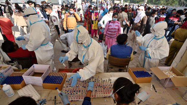 Health workers preserve swab samples collected from passengers arriving from other states, to test for coronavirus infection at Anand Vihar Bus Terminal in New Delhi on Thursday.(Biplov Bhuyan/HT File Photo)