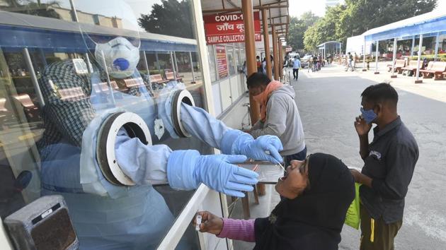 File photo: A health worker takes samples for Covid-19 testing at Ram Manohar Lohia Hospital in Lucknow.(PTI)
