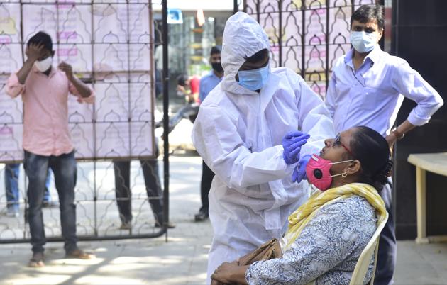 A health worker takes a swab sample of a resident.(Anshuman Poyrekar/HT Photo)