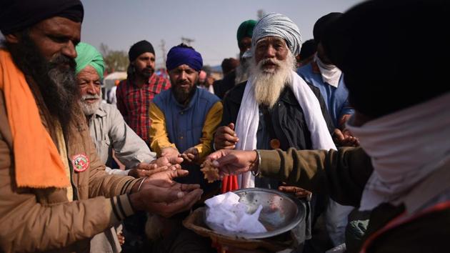 Farmers distribute “prasad” at the protest site Guru Nanak Dev Jayanti at Singhu border in New Delhi on November 30. Farmers protesting at the Tikri border and Singhu border were seen distributing prasad among each other and security personnel. (Biplov Bhuyan / HT Photo)