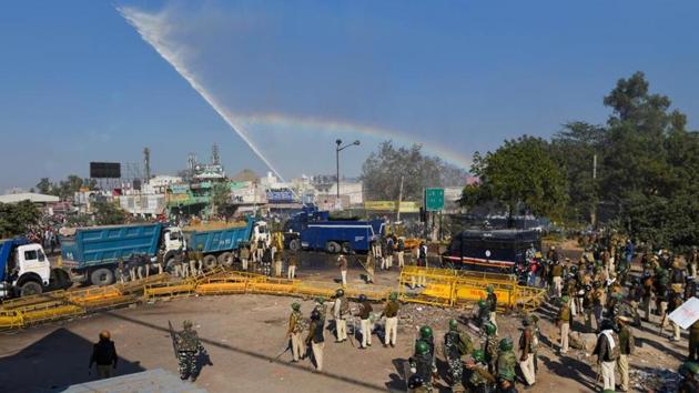 A water cannon is fired to disperse farmers marching to Delhi in protest against farm reform laws, at Singhu Border in New Delhi.(Sanchit Khanna /HT PHOTO)